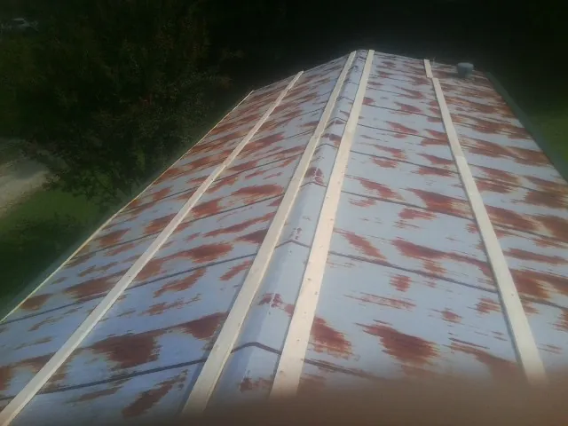 Rusted metal roof panels with new wood purlins before replacement — Storm Damage Roof Repair in Nekoma by Roofing Brothers