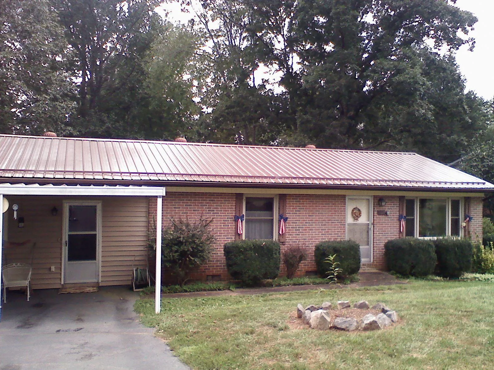 Bronze metal roof and carport on a brick ranch home — Roof Repair work by our crew in Nekoma